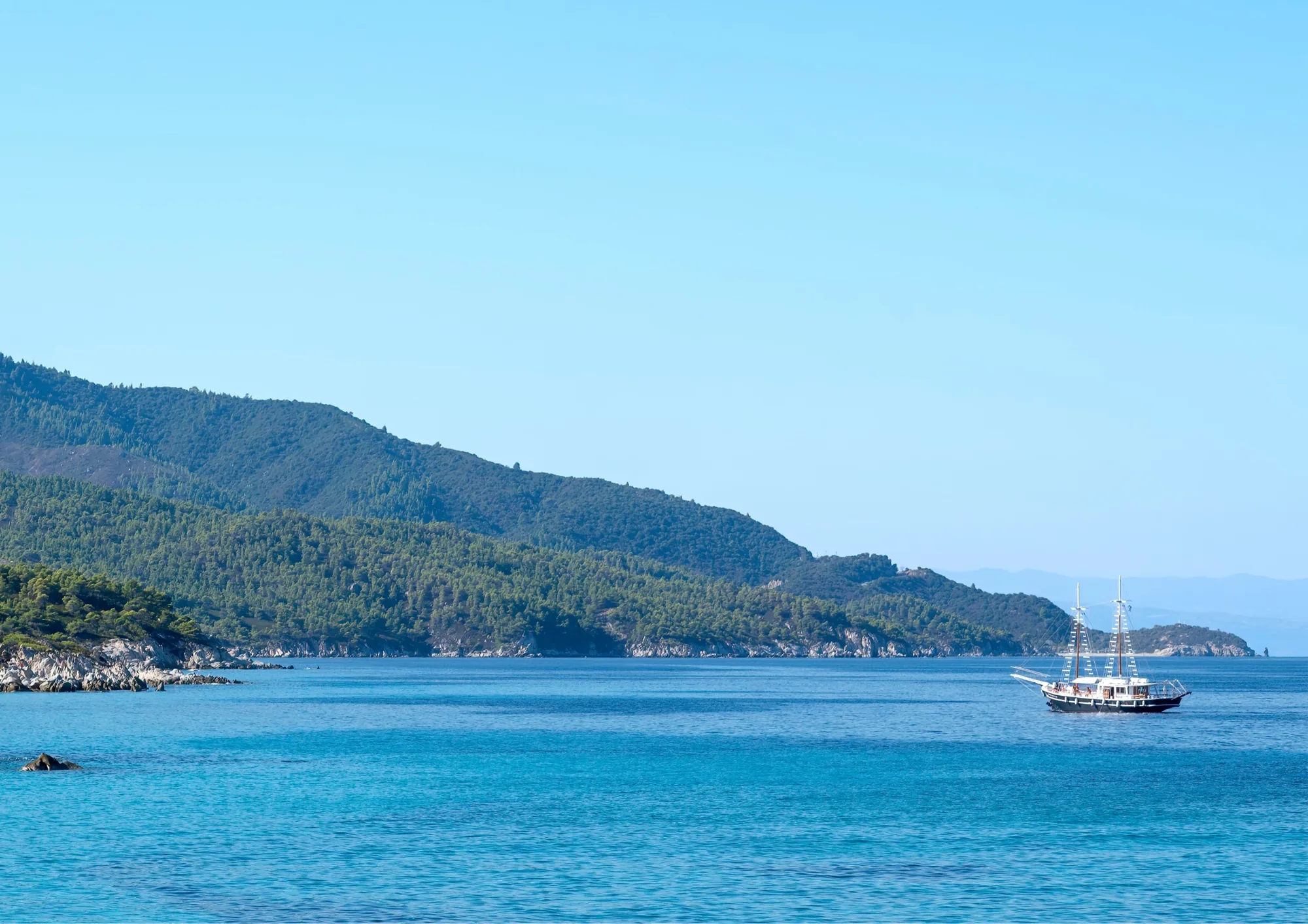 Sailing yacht cruising among Greek islands in the Mediterranean