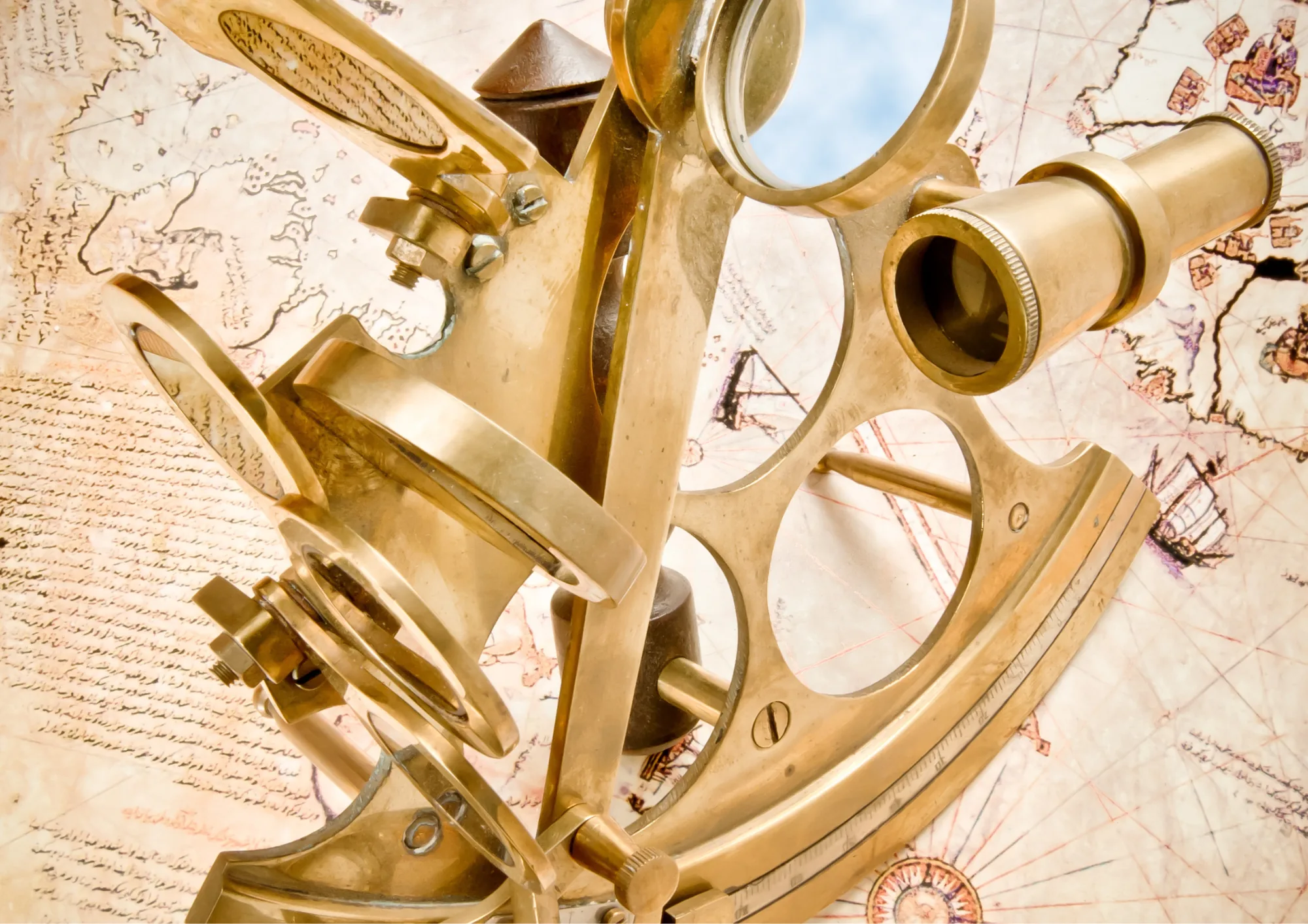 Brass sextant resting on an old nautical navigation chart